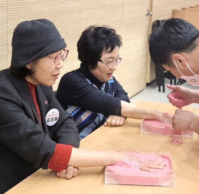 2024년 자원봉사 누적 2만 시간을 달성한 자원봉사자 2명이 핸드프린팅을 제작하고 있다. 박귀빈기자