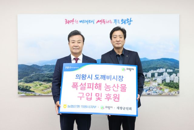 김원석 NH농협 의왕시지부장(오른쪽)이 폭설로 어려움을 겪은 부곡도깨비시장 상인들로부터 구입한 농산물을 의왕시재향군인회에 전달해 달라며 김성제 시장에게 기탁하고 있다. 농협 의왕시지부 제공