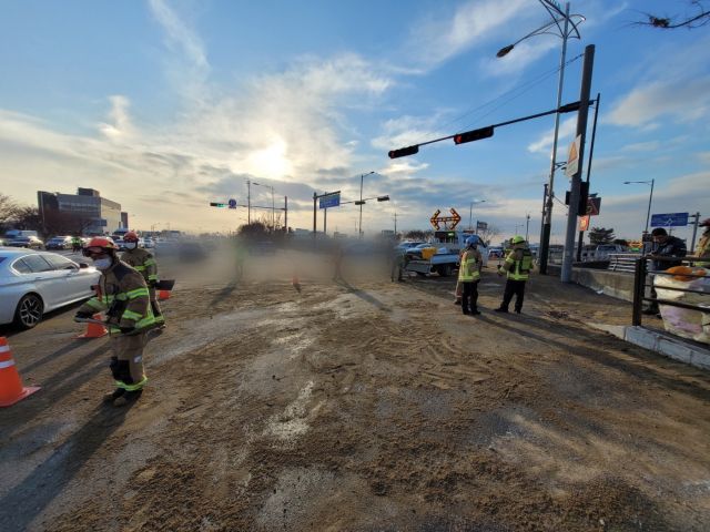소방당국과 고양시 관계자들이 9일 오후 고양시 일산서구 제2자유로 법곳IC 인근 도로에 유출된 화학물질을 제거한 후 차량 미끄럼 방지를 위해 모래를 뿌리고 있다. 일산소방서 제공