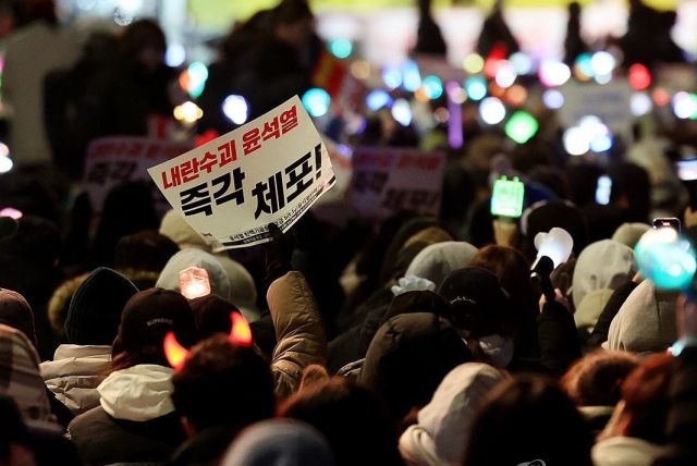 8일 오후 서울 여의도 국회 앞에서 열린 윤석열 탄핵 및 구속을 촉구하는 촛불문화제에서 참가자들이 관련 손팻말과 응원봉을 들고 있다. 연합뉴스