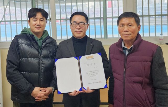 한희섭 제3대 수원시육상경기연맹 회장 당선자(가운데)가 당선증을 받고 있다.수원시육상경기연맹 제공