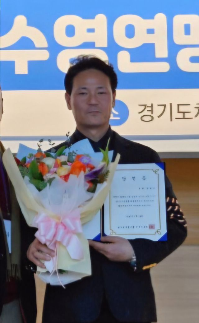 통합 3대 경기도수영연맹 회장선거에서 당된돼 연임에 성공한 김범준 회장이 당선증을 받고 있다.경기도수영연맹 제공