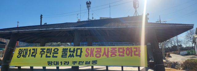 여주시 세종대왕면 왕대리 주민들이 SK용인산단 용수공급 문제로 난방공급이 중단돼 엄동설한에 마을회관으로 내몰리자 마을회관 앞에 공사 중단을 촉구하는 현수막을 내걸고 대책 마련을 호소하고 있다.유진동기자