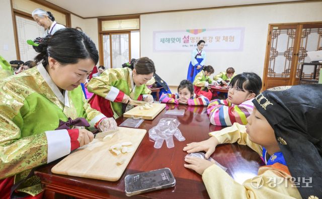 설날을 일주일 앞둔 22일 용인특례시 처인구 용인시예절교육관에서 열린 '새해 맞이 설 명절 특강 및 체험'에서 다문화가정 가족들이 직접 만든 떡국이 떡국 만들기 체험을 하고 있다. 윤원규기자