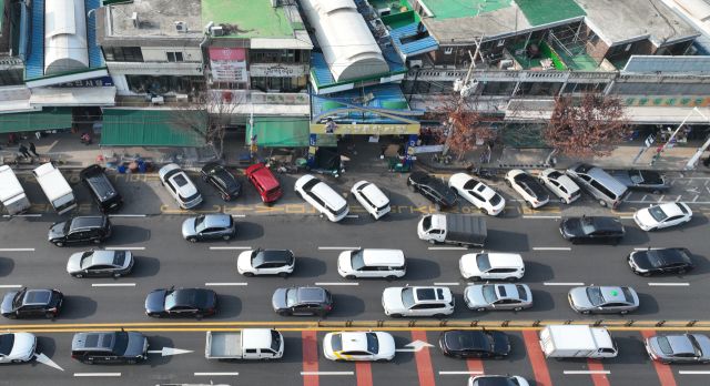 22일 인천 미추홀구 인천남부종합시장과 신기시장 앞 편도 4차로 도로변이 불법 주·정차한 차량들로 인해 정체를 빚고 있다. 조병석 기자