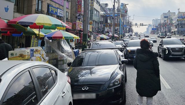 22일 오후 인천 남동구 모래내·구월시장 옆 도로, 주차할 곳이 없어 한 시민이 도로 한복판으로 나와 일행의 차량을 기다리고 있다. 장민재 기자