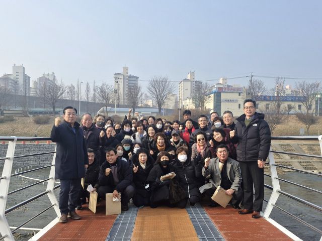 지난21일 남양주시 왕숙천에 설치된 인도교(스윙교) 임시개통식현장에서 주민설명회를 마치고 관계자들과 주민들이 함께 기념촬영을 하고 있다. 남양주시 제공