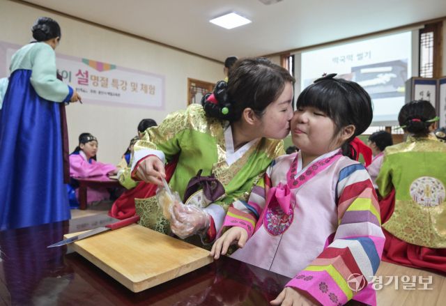 설날을 일주일 앞둔 22일 용인특례시 처인구 용인시예절교육관에서 열린 '새해 맞이 설 명절 특강 및 체험'에서 다문화가정 가족들이 직접 만든 떡국이 떡국 만들기 체험을 하고 있다. 윤원규기자