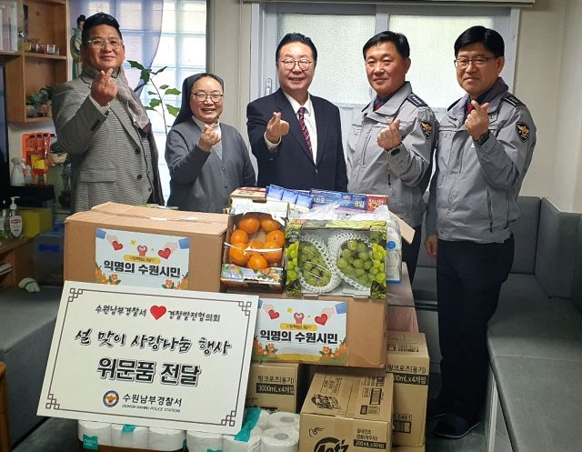 정준엽 수원남부경찰서장이 24일 아동양육시설 ‘수원 나자렛집’을 방문해 생필품과 익명의 시민이 매탄지구대에 기부한 핫팩을 전달하며 기념사진을 촬영하고 있다. 수원남부경찰서 제공