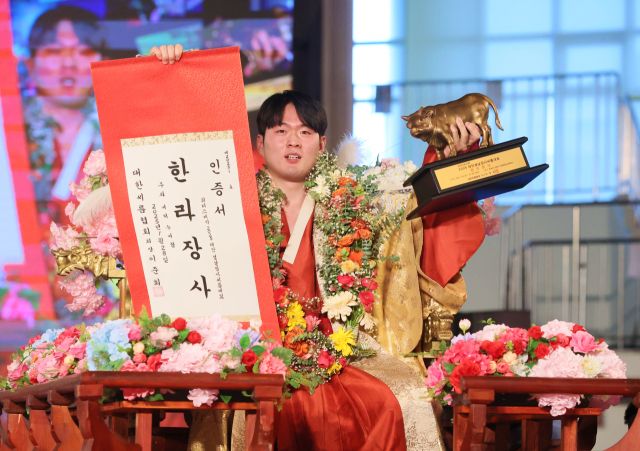28일 태안종합실내체육관에서 열린 ‘위더스제약 2025 태안설날장사씨름대회’ 한라장사(105㎏이하)에 등극한 박민교(용인특례시청)가 장사 꽃가마를 타고 장사인증서와 황소트로피를 들고 기념사진을 찍고 있다. 대한씨름협회 제공