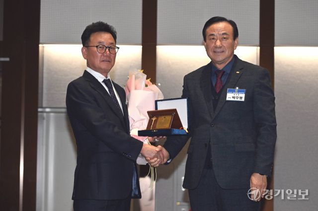 4일 오후 수원컨벤션센터에서 열린 '수원중·고등학교총동문회 2025 신년인사회, 회장 이·취임식 및 111년사 출판기념회'에서 박주왕 제25대 회장이 김상춘 제24대 회장에게 감사패를 전달하고 있다. 김시범기자