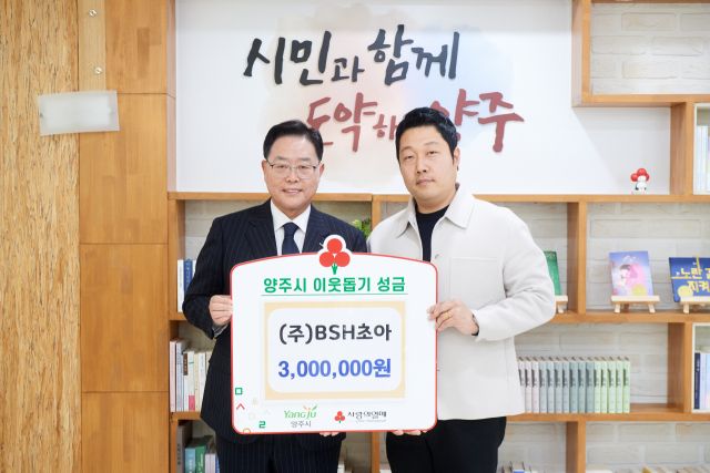 (주)비에스에이치초아 배지훈 대표가 강수현 양주시장에게 이웃돕기 성금 300만원을 전달한 뒤 기념사진을 찍고 있다. 양주시 제공