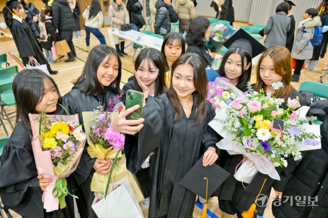 6일 오전 수원특례시 장안구 한일초등학교에서 열린 졸업식에서 졸업생들이 친구와 함께 사진을 찍으며 초등학교 마지막 추억을 남기고 있다. 윤원규기자