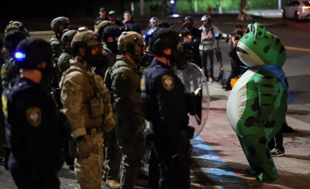 포틀랜드에서 개구리 복장으로 ICE 요원과 대치 중인 한 시위자. 로이터=연합뉴스