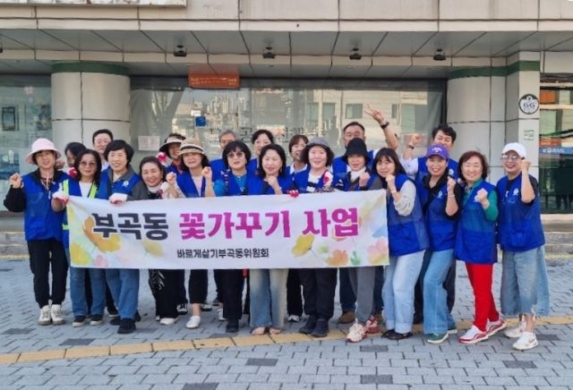 의왕시 부곡동 바르게살기위원회 김준기 위원장과 위원들이 의왕역 앞 화단 잡초를 제거하고 국화를 식재하는 ‘부곡동 꽃 가꾸기’행사를 실시한 뒤 기념촬영을 하고 있다. 의왕시 제공