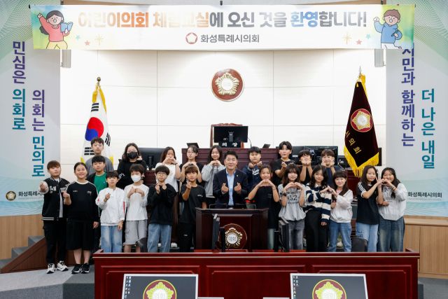 어린이의회 체험 교실에서 배정수 화성특례시의회 의장(가운데)와 신남초등학교 학생들이 기념촬영을 하고 있다.