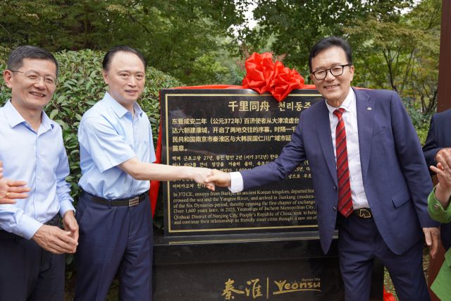 이재호(오른쪽) 연수구청장과 링샹치엔 친화이구 구장이 중국 난쑤성 난징시 친화이구 상심정에서 ‘우호 상징 표지석 제막식’을 한 뒤 악수하고 있다. 연수구 제공