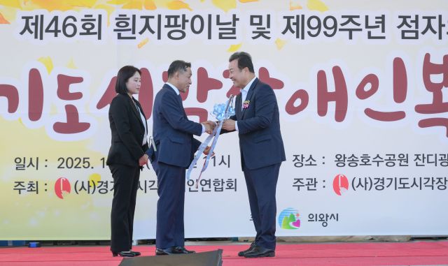 16일 의왕시 왕송호수공원 잔디광장에서 열린 '제46회 흰지팡이날 및 제99회 점자의날 기념 경기도시각장애인복지복지대회'에서 김성제 의왕시장이 정태곤 시각장애인연합회장에게 흰지팡이를 건네고 있다. 윤원규기자