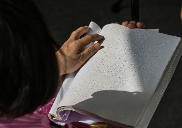 16일 의왕시 왕송호수공원 잔디광장에서 열린 '제46회 흰지팡이날 및 제99회 점자의날 기념 경기도시각장애인복지복지대회'중 점자경시대회 점자 속독 부문에 참가한 한 선수가 점자책을 읽고 있다. 윤원규기자