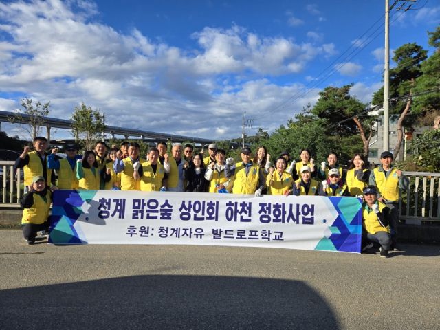 의왕 청계 맑은 숲 먹거리마을 상인회와 청계자유 발도르프학교 학부모들이 의왕시 청계천 일대에서 하천 정화 활동을 펼친 뒤 기념촬영을 하고 있다. 의왕시 제공