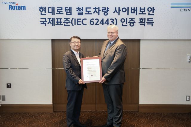 이원상 현대로템 RS기술리더(왼쪽)와 비달 도로넨(Vidar Dolonen) DNV 명예영사가 제품 인증서를 들고 기념촬영을 하고 있다. 현대로템 제공