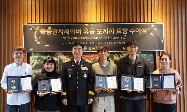 유해공 김포소방서장이 신속한 심폐소생술로 소중한 생명을 살린 풍무역 스타벅스 DT점 직원들에게 하트세이버 표창을 수여한 뒤, 기념사진을 촬영하고 있다. 김포소방서 제공