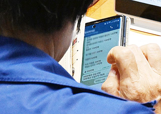 국회 과학기술정보방송통신위원장인 더불어민주당 최민희 의원이 26일 국회 본회의장에서 딸 축의금과 관련한 텔레그램 메시지를 보고 있다. 연합뉴스 제공