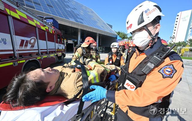 27일 오후 광명시민체육관에서 열린 '2025년 재난대응 안전한국훈련'에서 소방관계자가 부상당한 소방관을 들것을 이용해 이동시키고 있다. 광명시, 광명소방서, 광명경찰서 등 8개 기관이 참여한 이번 훈련은 다중밀집시설 대형화재를 가장해 대피, 인명구조, 복구활동 등의 훈련을 진행했다. 홍기웅기자