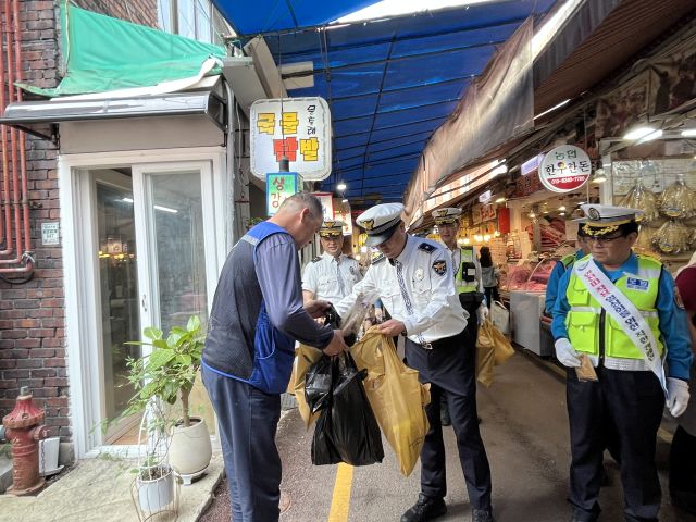 안양동안경찰서가 호계시장에서 추석 연휴를 앞두고 전통시장 방문객을 대상으로 교통질서 확립 캠페인을 진행하고 있다. 안양동안경찰서 제공