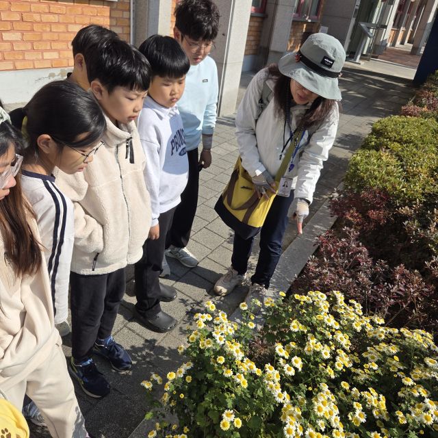 이천 신둔초 학생들이 자연 속에서 배우는 생태 융합수업 ‘학교숲 체험교실’에서 해설사로부터 꽃에 대한 이야기를 듣고 있다. 신둔초 제공