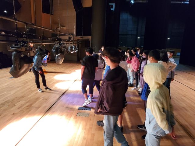 군포문화예술회관 수리홀에서 학생들이 조명 담당자로 부터 조명작동 원리에 대해 설명을 듣고 있다. 군포문화예술회관 제공