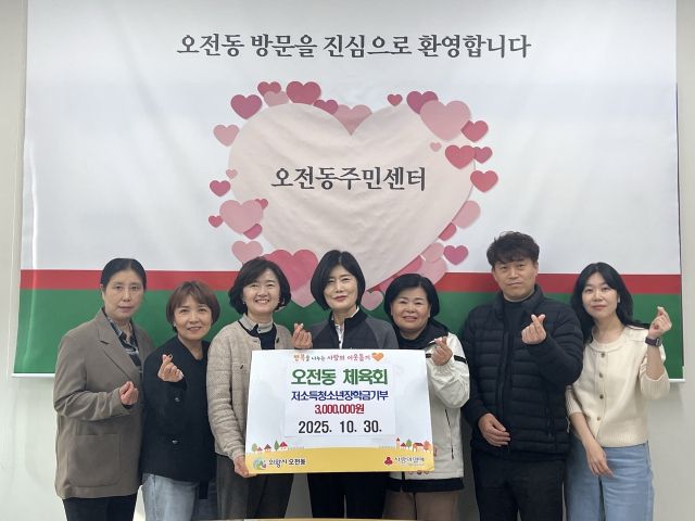 조영순 의왕시 오전동체육회장(가운데)과 회원들이 신화정 오전동장(왼쪽 세번째)에게 장학금을 기부한 뒤 기념촬영을 하고 있다. 의왕시 제공