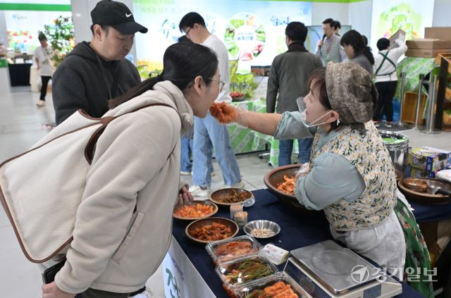 15일 ‘2025 코리아푸드페어(구 대한민국 명품특산물 페스티벌)’를 찾은 한 관람객이 시식용 김치를 맛보고 있다. 홍기웅기자