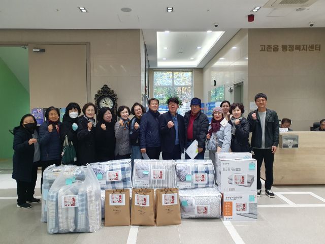 고촌읍 지역사회보장협의체 위원들이 ‘한파대비 따뜻한 겨울나기 물품’을 기탁하며 기념사진을 촬영하고 있다. 고촌읍 행정복지센터 제공