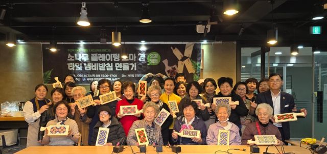 사우동 행정복지센터에서 열린 ‘목공 수업’ 어르신 등 사우동 주민들이 도마 겸 타일 냄비 받침대를 만 뒤, 작품을 들어보이며 기념촬영을 하고 있다. 사우동 행정복지센터 제공
