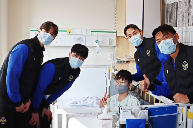 인천유나이티드 선수들이 인하대병원 소아병동에 입원 치료 중인 환아와 기념 사진을 찍고 있다. 인하대병원 제공