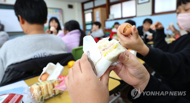 학교 비정규직 노동자들이 파업에 돌입한 20일 인천 한 초등학교 교실에서 학생들이 구운 달걀, 주스, 햄치즈샌드위치 등 대체식으로 점심을 먹고 있다. 연합뉴스
