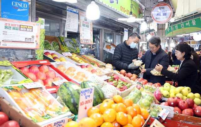김동연 경기도지사가 22일 의정부에서 열린 ‘2025년 하반기 경기 살리기 통큰세일’ 개막식 참석한 뒤 의정부제일시장에서 경기지역화폐로 과일과 채소 등을 구입하며 현장의 목소리에 귀를 기울이고 있다. 경기도 제공