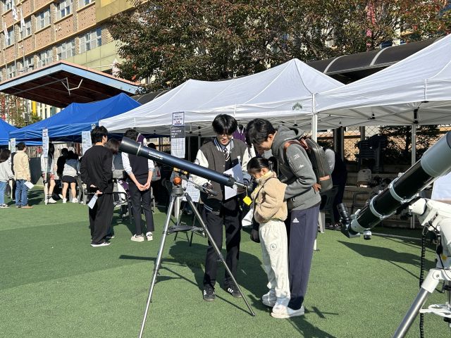 ‘운정고등학교 융합체험전’에서 참가자가 운정고 학생의 도움을 받아 굴절망원경의 초점을 맞춰보고 흑점을 관측하는 체험을 하고 있다. 운정고 제공
