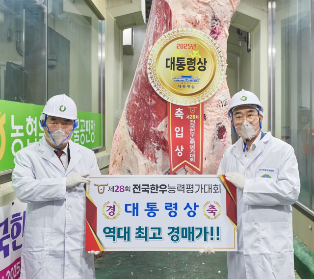 이영상 동원홈푸드 축육부문 대표(오른쪽)와 이재윤 한국종축개량협회 회장(왼쪽)이 5일 충북 음성에서 열린 '제28회 전국한우능력평가대회'에서 대통령상 한우를 낙찰받고 기념 촬영을 하고 있다. 동원홈푸드 제공