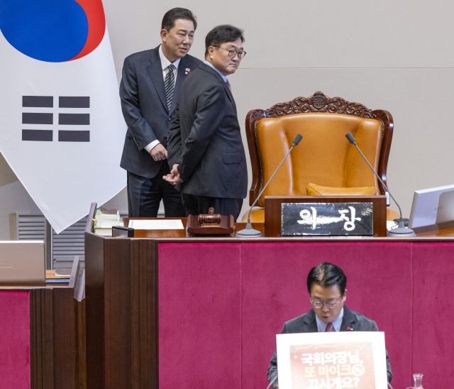 우원식 국회의장과 더불어민주당 김병기 원내대표가 11일 국회에서 열린 12월 임시국회 1차 본회의에서 국민의힘 곽규택 의원이 형사소송법 일부개정법률안에 대한 무제한 토론(필리버스터)에 손팻말을 이용하는 것에 대해 의견을 나누고 있다. 연합뉴스