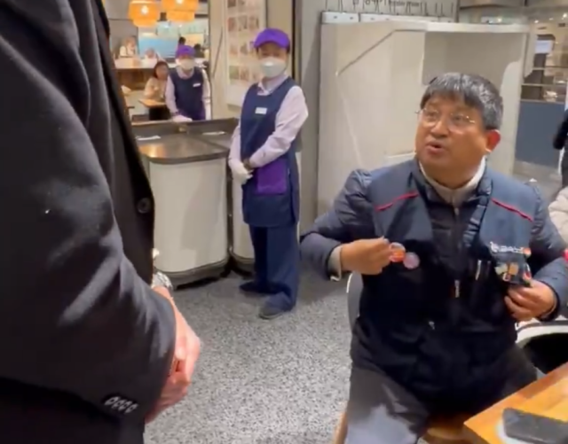 백화점 보안요원에 항의하는 이김춘택 사무장. X(옛 트위터) 갈무리