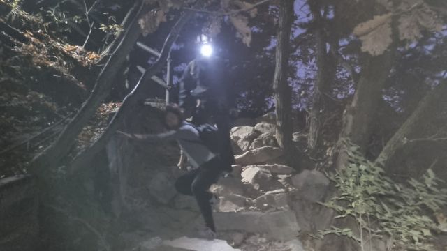 지난달 7일 북한산 산행 중 조난당한 싱가포르 국적 여행객들이 고양소방서 구조대원의 도움 속에 하산하고 있다. 고양소방서 제공