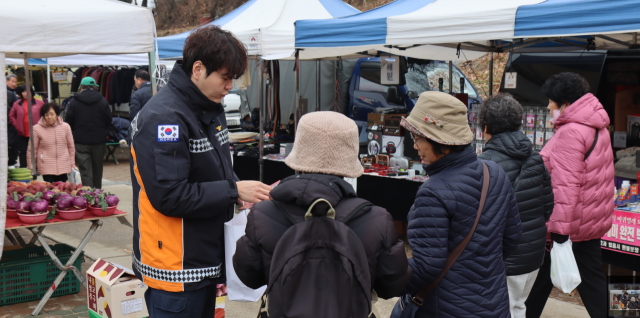 포천소방서 대원이 신읍동 전통시장에서 시민과 상인을 대상으로 ‘119안심콜서비스’ 홍보 캠페인을 진행하고 있다. 포천소방서 제공
