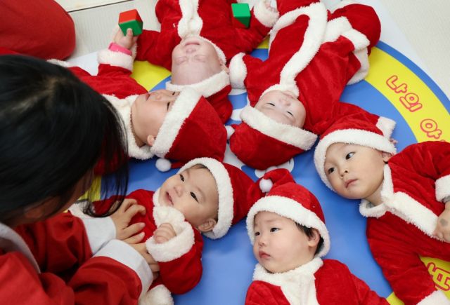 성탄절을 일주일 앞둔 18일 광주시 능평도서관에서 열린 '산타와 함께하는 첫 만남, 책! 행복한 우리 아기를 위한 시간' 행사에서 산타 복장의 엄마와 아기들이 체험형 놀이 활동을 하고 있다. 이번 행사는 한토이어린이서점 주관으로 진행했다. 김시범기자