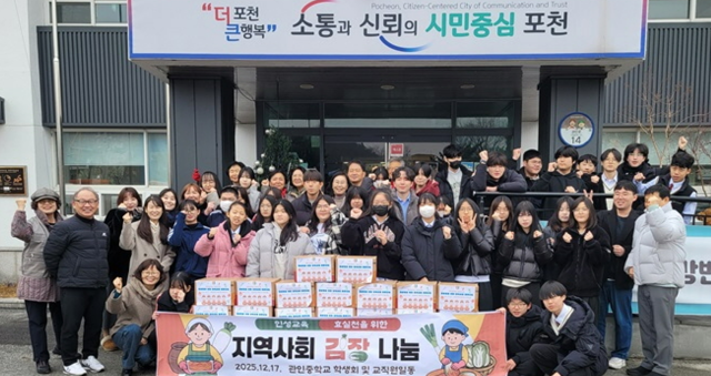 관인중학교 학생들이 정성껏 담근 김장김치를 관인면행정복지센터에 기탁하고 기념촬영을 하고 있다. 관인면행정복지센터 제공