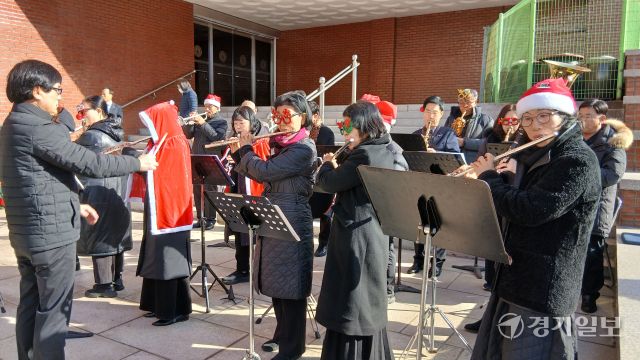 성탄절을 나흘 앞둔 21일 오전 수원특례시내 한 교회 앞에서 산타복을 입은 오케스트라 대원들이 다양한 크리스마스 캐럴을 연주하며 성탄 분위기를 고조시키고 있다. 김시범기자