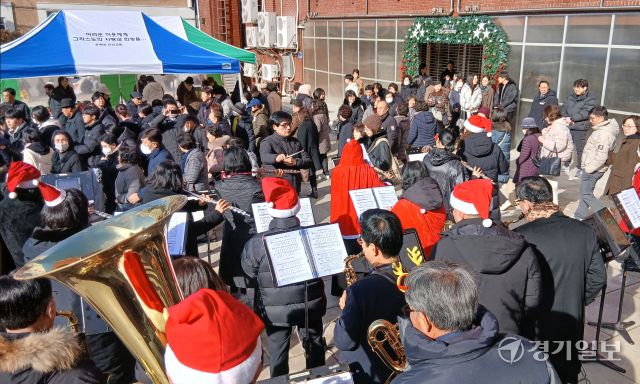 성탄절을 나흘 앞둔 21일 오전 수원특례시내 한 교회 앞에서 산타복을 입은 오케스트라 대원들이 다양한 크리스마스 캐럴을 연주하며 성탄 분위기를 고조시키고 있다. 김시범기자