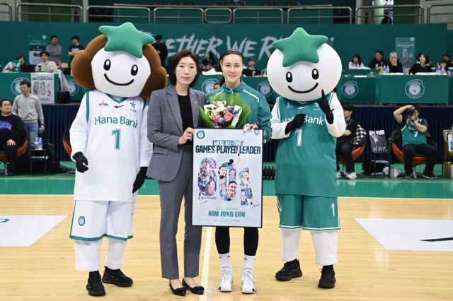 부천 하나은행 김정은(오른쪽)이 21일 부천체육관에서 열린 BNK금융 2025-2026 여자프로농구(WKBL) 정규리그 아산 우리은행전서 개인 통산 601번째 출전을 기록해 임영희 우리은행 코치와 기념촬영을 하고 있다. WKBL 제공