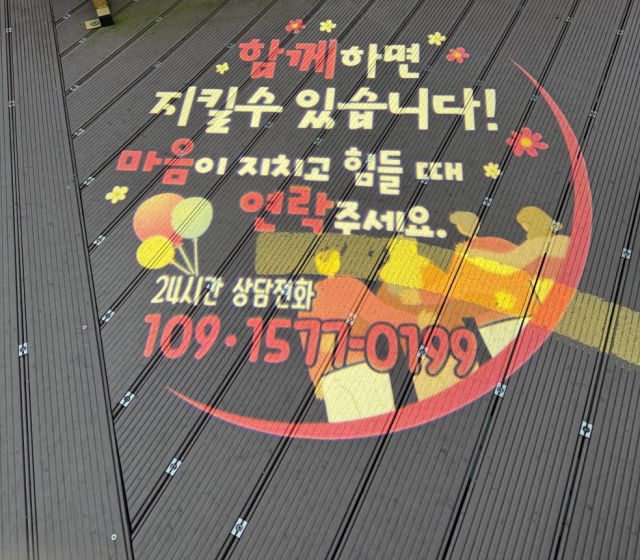 의왕시보건소가 백운호수 생태탐방로에 설치한 정서적 위로를 전하는 내용의 로고젝터. 의왕시 제공